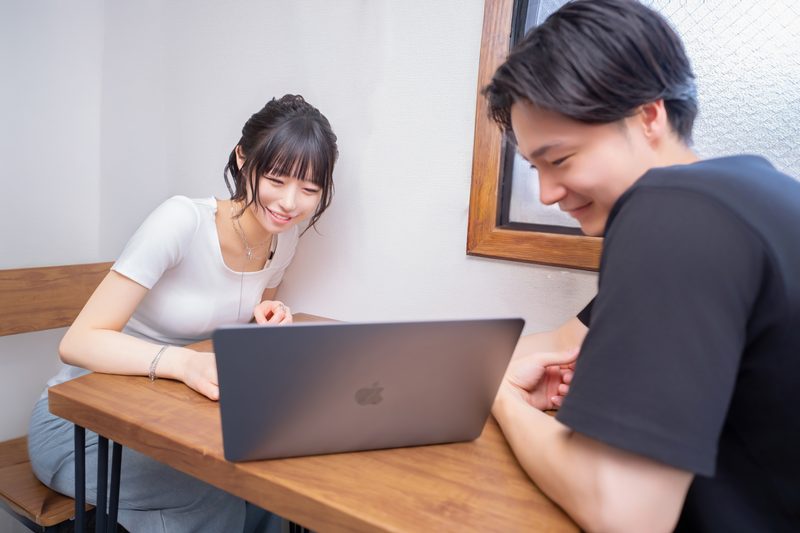 面接でパソコンを使って説明を受けるセラピスト