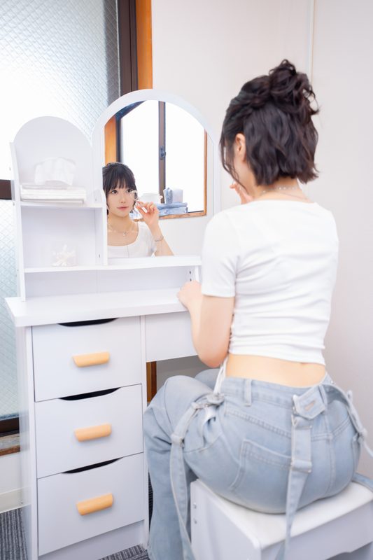 ドレッサーで出勤前の準備をするセラピスト